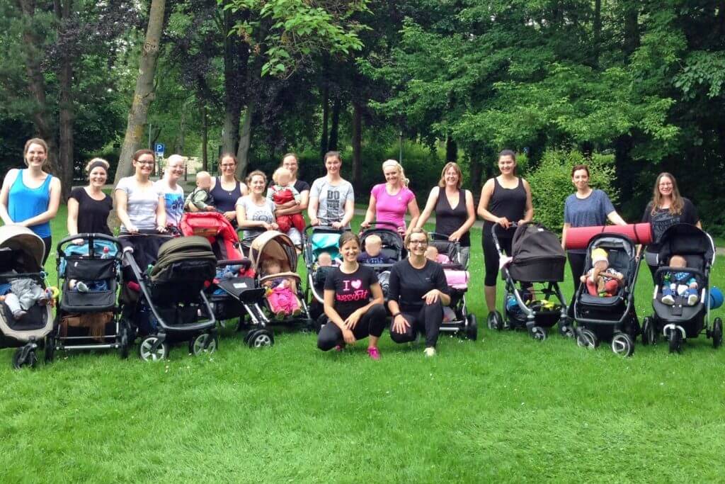 Gruppe von Mamas mit Kinderwagen beim buggyFit-Kurs im Park