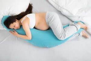 High Angle View Of Pregnant Woman Sleeping On Bed