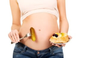 Pregnant woman holding prickle and cake