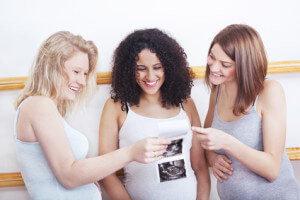 Pregnant women looking at ultrasound