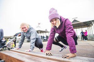 Zwei Frauen machen Fitnessübungen an der Bank.