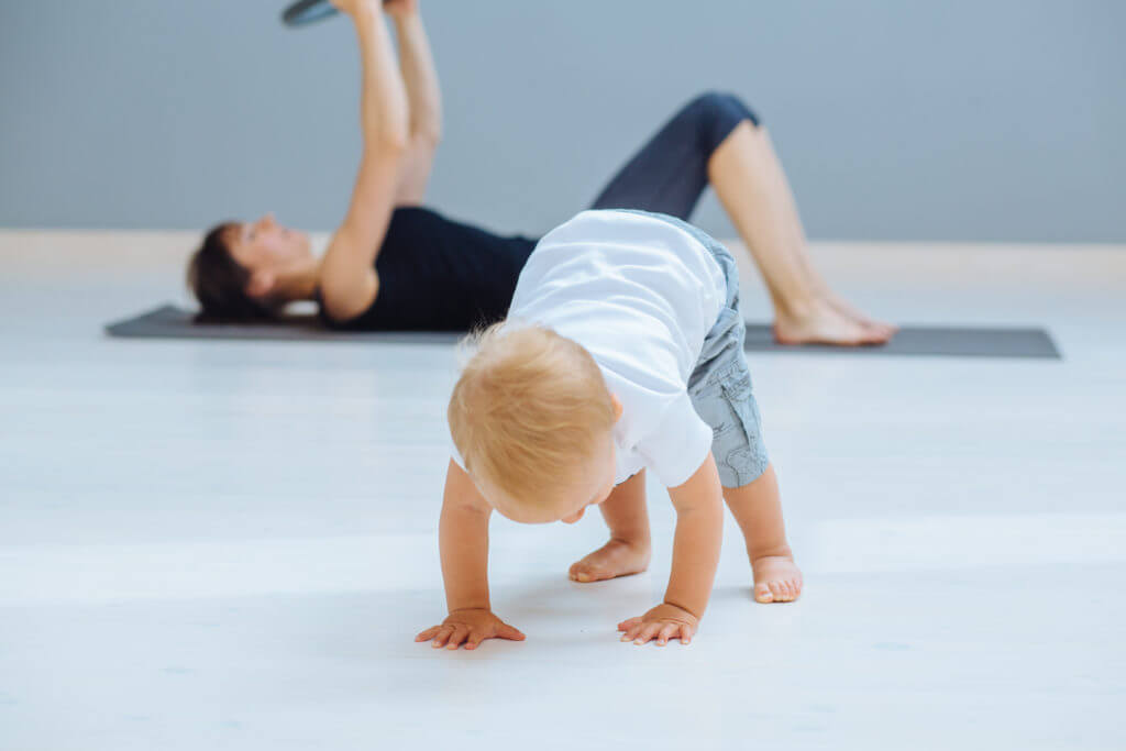 Mama macht Pilates mit Baby.