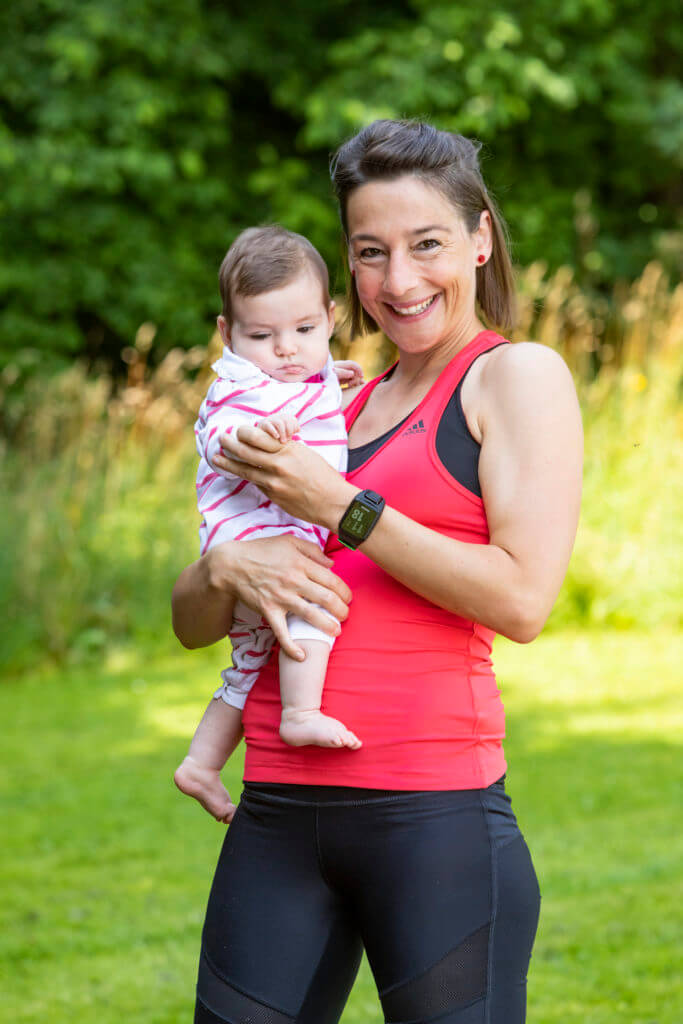 Mama lächelt mit ihren Baby zusammen.