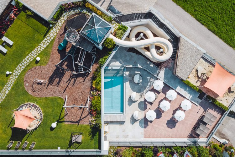 Ein Hotel mit Pool von oben fotografiert. Familotel Huber