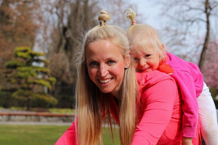 Fitnessmama bei einer Übung zusammen mit ihrer Tochter.